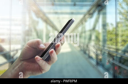 Junge bemannt Hand Handy im Bürogebäude Stockfoto