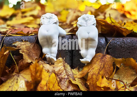 Lustige weißer Keramik Engel mit kleinen Flügeln sind zurück im Herbst Park. Stockfoto