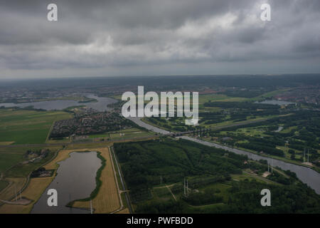 Bauernhöfe in Holland, Niederlande mit Kanal von Ebene im Himmel mit Wolken aus dem Fenster im Flugzeug gesehen Stockfoto