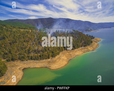 Rauch steigt aus Wald am Ufer des Tumut River. Blowering, NSW, Australien Stockfoto