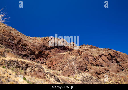 Gran Canaria, Oktober, Landschaften von Tal von Agaete, erodiert mountain Montana de Berbique mit frühen Höhle Komplexe Cuevas de Berbique Stockfoto