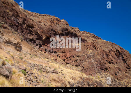 Gran Canaria, Oktober, Landschaften von Tal von Agaete, erodiert mountain Montana de Berbique mit frühen Höhle Komplexe Cuevas de Berbique Stockfoto