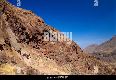 Gran Canaria, Oktober, Landschaften von Tal von Agaete, erodiert mountain Montana de Berbique mit frühen Höhle Komplexe Cuevas de Berbique Stockfoto