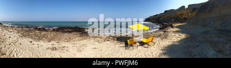 Panorama von zwei Yellow Lounge Liegen und ein Sonnenschirm am Strand von einer tropischen Insel vor dem Meer. Grafik für Web Design. Stockfoto