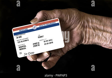 Eine ältere weibliche Hand hält eine mock United Landesregierung Medicare Health Insurance Card. Es ist eine generische Karte. Dies ist ein Foto Illustration. Stockfoto