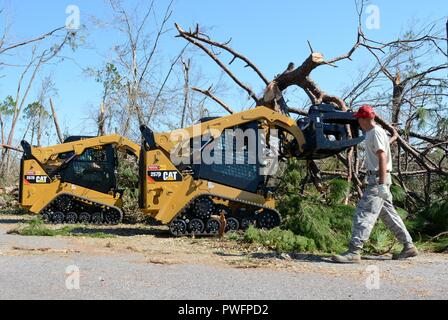 Master Sgt. Christopher Fischer, schwere Ausrüstung Fahrer, Guides Staff Sgt. Alex Spano, elektrische Facharbeiter und Senior Airman Gonard Caudill, Heavy Equipment operator, alle aus den 202. Geben Sie der Camp Blanding, Fla. im Kompaktlader verwenden ein gefallener Baum auf Debi Straße im Bayou George Gegend von Panama City Oktober 14, 2018, 14. Oktober 2018 zu löschen. Die GEBEN Sie auf Für ihr Know-how in der effizienten Route clearing genannt nach dem Hurrikan Michael durch kamen. (U.S. Air National Guard Foto: Staff Sgt. Carlynne DeVine). () Stockfoto