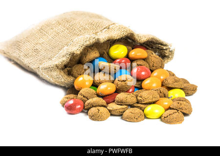 Bunte pepernoten behandelt in Jute Tasche auf weißem Hintergrund für die jährliche Sinterklaas holiday Event in den Niederlanden am 5. Dezember Stockfoto