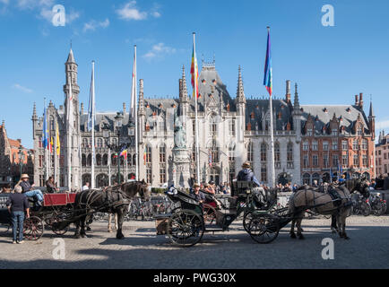 Pferdewagen, warten auf Touristen, mit provinziellen Gericht und Historium Gebäude im historischen Zentrum der mittelalterlichen Stadt Brügge, Westflandern, Belgien Stockfoto