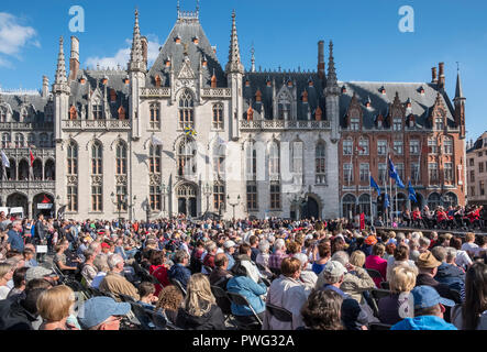 Ein Publikum genießen ein Open Air Konzert der an einem sonnigen Tag im September auf dem Marktplatz, Markt, Brügge, Flandern, Belgien. Stockfoto