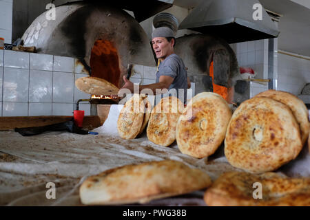 Ein usbekischer Mann, der Naan im Ofen gebackenes Fladenbrot auf dem Chorsu-Basar, auch Charsu-Basar genannt, im Zentrum der Altstadt von Taschkent, der Hauptstadt Usbekistans, backt Stockfoto