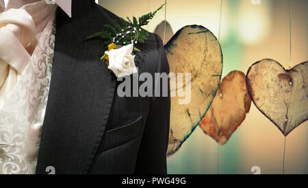 Mens Hochzeit Anzug schließen bis auf Holz Herz Hintergrund mit weißen Rose. Stockfoto