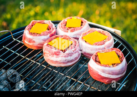 Die hausgemachte Bier kann Bacon Burger am Grill zubereitet. Vorbereitung gefüllte Pastetchen, in Speck umwickelt und Grillen auf indirekte Hitze in der Natur an der Bac Stockfoto