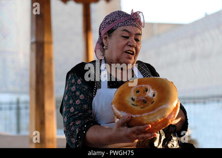 Ein Händler mit Goldzähnen, der im Siyob Bazaar traditionelles, nicht oder naan gebackenes Fladenbrot im Buchara-Stil verkauft, wird auch Siab Bazaar genannt, der größte Basar in der Stadt Samarkand, alternativ Samarqand in Usbekistan. In Usbekistan und anderen Ländern Zentralasiens war der Austausch von natürlichen Zähnen durch Goldimplantate oder -Kappen einst ein Statussymbol und Prestige. Die jüngere Generation folgt dieser Tradition jedoch selten. Stockfoto