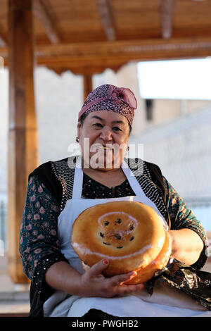 Ein Händler mit Goldzähnen, der im Siyob Bazaar traditionelles, nicht oder naan gebackenes Fladenbrot im Buchara-Stil verkauft, wird auch Siab Bazaar genannt, der größte Basar in der Stadt Samarkand, alternativ Samarqand in Usbekistan. In Usbekistan und anderen Ländern Zentralasiens war der Austausch von natürlichen Zähnen durch Goldimplantate oder -Kappen einst ein Statussymbol und Prestige. Die jüngere Generation folgt dieser Tradition jedoch selten. Stockfoto