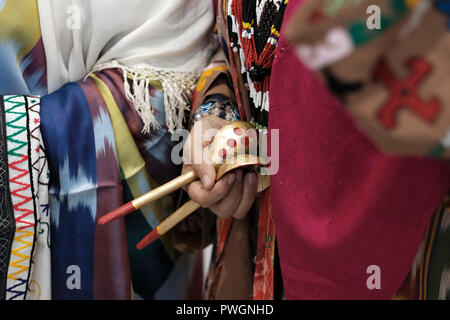 Eine usbekische Frau in traditioneller Kleidung aus der Region Surkhandarya nahe der südlichen Grenze zu Tadschikistan, die Holzlöffel für rhythmische Percussion verwendet, um den „Raqs-e Koshik“ oder den Löffeltanz in Usbekistan zu begleiten Stockfoto