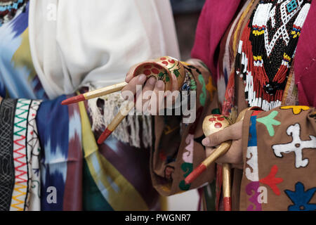 Eine usbekische Frau in traditioneller Kleidung aus der Region Surkhandarya nahe der südlichen Grenze zu Tadschikistan, die Holzlöffel für rhythmische Percussion verwendet, um den „Raqs-e Koshik“ oder den Löffeltanz in Usbekistan zu begleiten Stockfoto