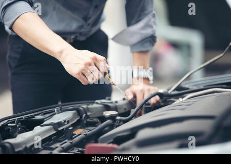 Unternehmer helfen Unternehmerinnen überprüfen kaputte Autos reparieren und Stockfoto