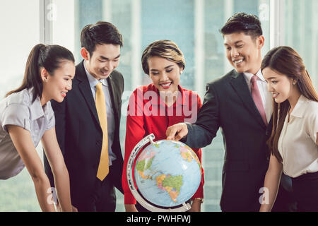 Eine Gruppe von Geschäftsleuten suchen bei Globe Stockfoto