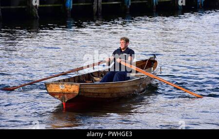 Man Rudern ein Selbst mieten Ruderboot auf den See Windermere und Bowness on Windermere, Lake District, Cumbria, England, Großbritannien Stockfoto