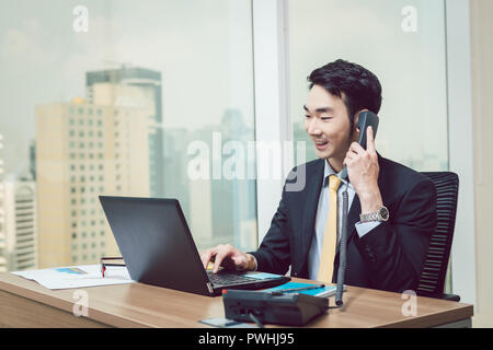 Lächelnde junge Unternehmer Arbeiten am Laptop Stockfoto