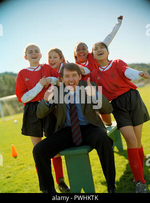 Fußball-Mannschaft und Trainer posieren für ein Foto. Stockfoto