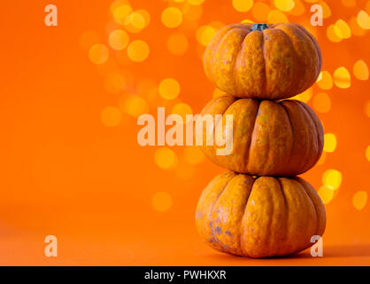 Halloween Kürbisse gegen helles Orange verschwommen Lichter Hintergrund Stockfoto