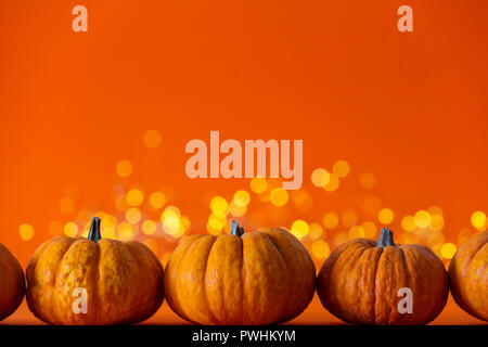 Halloween Kürbisse gegen helles Orange verschwommen Lichter Hintergrund Stockfoto