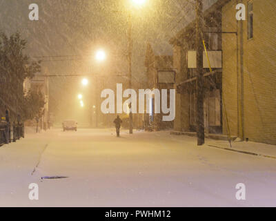 Quebec, Kanada. Ein Mann zu Fuß eine Stadt Straße in Joliette, während ein Schneesturm. Stockfoto