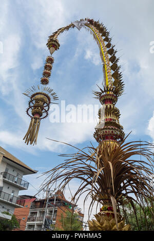 Traditionelle balinesische penjors entlang der Straße von Bali, Indonesien. Hohe Bambusstäbe mit Dekoration sind zu Ehren des hinduistischen Götter auf religiöse Festi eingestellt Stockfoto