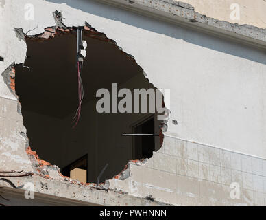 Riesiges Loch mit Drähten hängend in einem Gebäude an der Wand und Raum kopieren Stockfoto