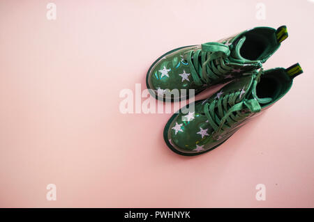 Grüne schuhe Leder Kind mit Sternen Muster auf rosa Hintergrund mit Copyspace. Stockfoto