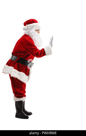 Volle Länge Profil Schuß von Santa Claus winken auf weißem Hintergrund Stockfoto