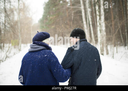 Senior Paar im Winter Wald Rückansicht Stockfoto