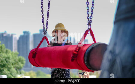 Wuhan, Hubei, China - 08. September 2018: Frau schlägt zu die grosse Glocke in der Yellow Crane Tower. Dieser Ort ist einer der bekanntesten in Wuhan. Stockfoto