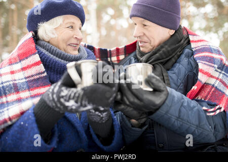 Senior Paar trinken Kakao im Winter Park Stockfoto