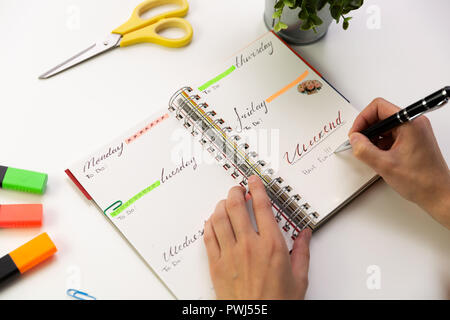 Die Frau Hände mit Kugelschreiber schreiben in Routenplaner. Moderne Büro Schreibtisch. Arbeiten, Konzept schreiben Stockfoto