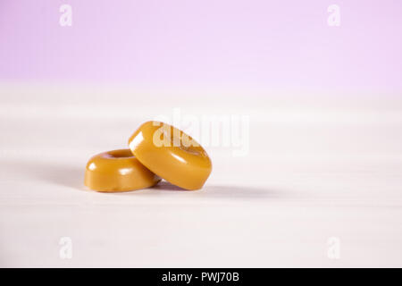 Gruppe von zwei ganze Caramel Cream candy butterscotch Sorte mit Pastell rosa im Hintergrund Stockfoto