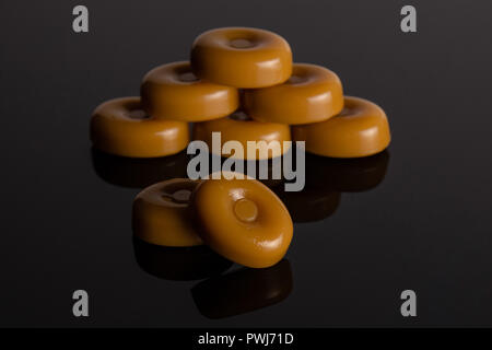 Gruppe der Acht ganze Caramel Cream candy butterscotch Vielfalt auf schwarzem Glas Stockfoto