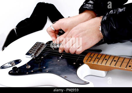 Person Tuning eine Gitarre aus der Kopfplatte auf weißem Hintergrund Stockfoto
