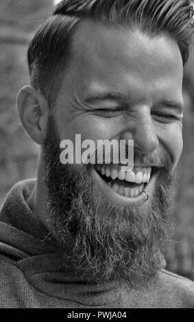 Junger Mann mit Bart wirklich hart zu lachen. Stockfoto