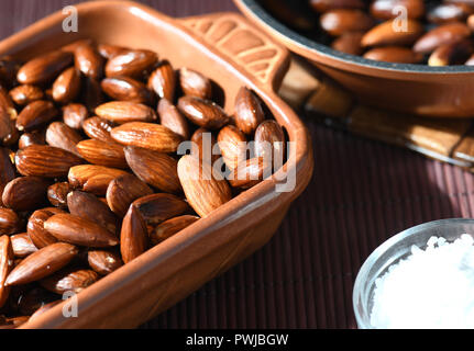 Fleischlichen gerösteten Mandeln in Olivenöl gekocht und mit Salz bestreut Schuß für Kopie Platz mit einem unscharfen Hintergrund Stockfoto