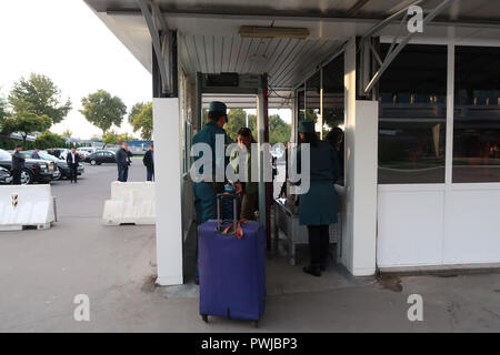 Fahrgäste in Security Checkpoint vor dem Betreten des Taschkent Yuzhny Internationalen Flughafen in Taschkent die Hauptstadt von Usbekistan, das geprüft wird, Stockfoto