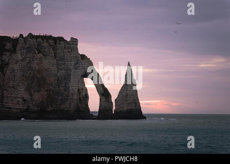 Ein windig und kalt lila Abend in Etretat, Normandie, Frankreich, berühmten Felsen und Klippen bei Sonnenuntergang Stockfoto