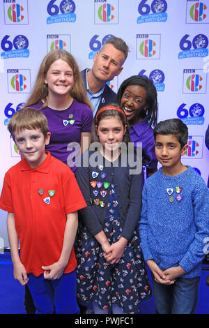 (Zurück) Tim Vincent und Diane-Louise Jordanien mit Kindern trägt blaue Peter Abzeichen, da sie alle Big Blue Peter's Geburtstag, feiert 60-jähriges Jubiläum der Show, bei der BBC Philharmonic Studio in der Media City UK, Salford. Stockfoto