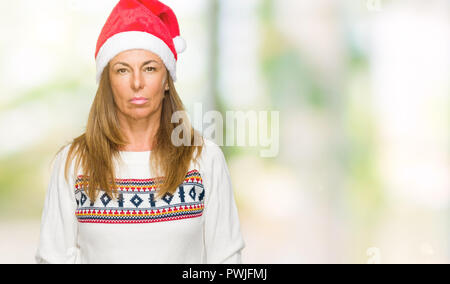 Mittleres Alter erwachsene Frau tragen winter Pullover und chrismat hat über isolierte Hintergrund mit ernsten Gesichtsausdruck. Einfache und natürliche auf der Suche Stockfoto