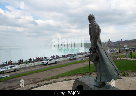 NIAGARA FALLS, ONTARIO, Kanada - 21. MAI 2018: Nikola Tesla Skulptur im Queen Victoria Park mit den Horseshoe Falls im Hintergrund. Stockfoto