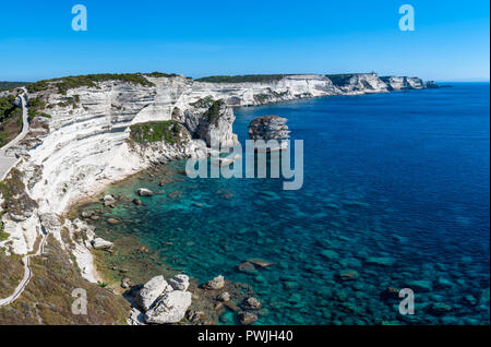 Panoramablick auf den Klippen von Bonifacio und die Grain de Sable im Süden von Korsika, mit Blick auf einen ruhigen blauen Meer unter blauem Himmel. Stockfoto