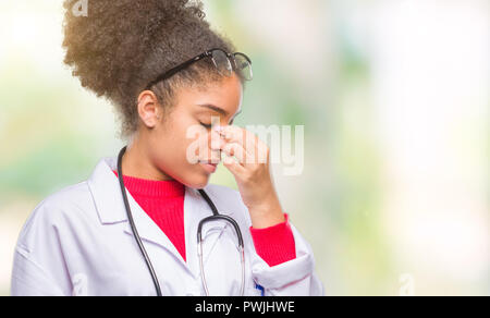 Junge afro-amerikanische Arzt Frau über isolierte Hintergrund Müde rieb Nase und Augen Gefühl der Müdigkeit und Kopfschmerzen. Stress und Frustration Konzept. Stockfoto