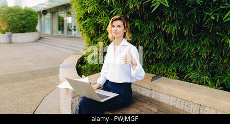 Geschäftsfrau, Arbeiten mit Laptop und Dokumente in Open Air, showin Stockfoto