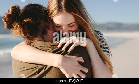 Nahaufnahme von Frau umarmt ihren Freund mit Liebe am Strand. Paar einander umarmen am Strand. Stockfoto